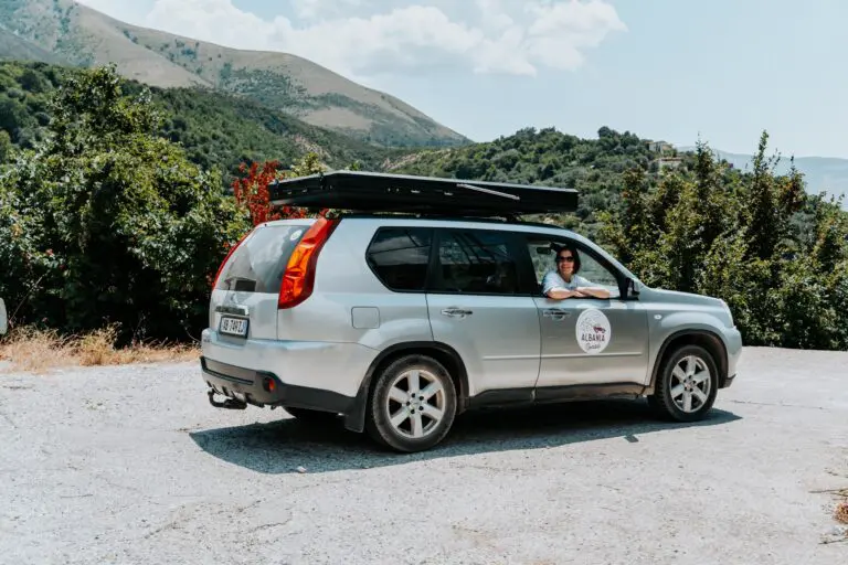 woman in car with rooftop tent in Albanian mountains