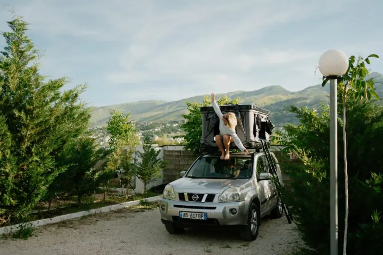 woman on rooftop tent of car in Albania mountains