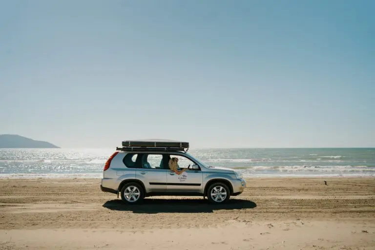 silver SUV with roof tent parked on a sunny beach in Albania