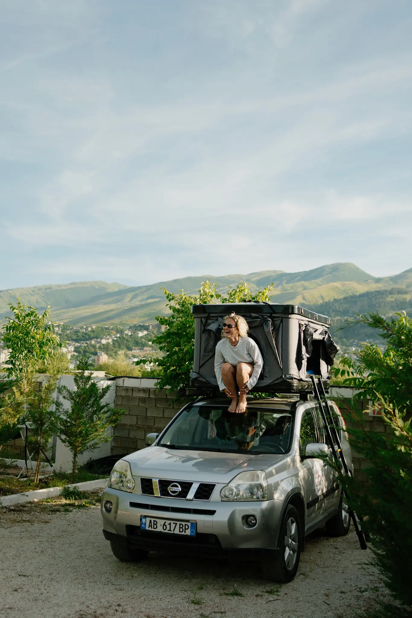woman on car roof tent in Albania mountains