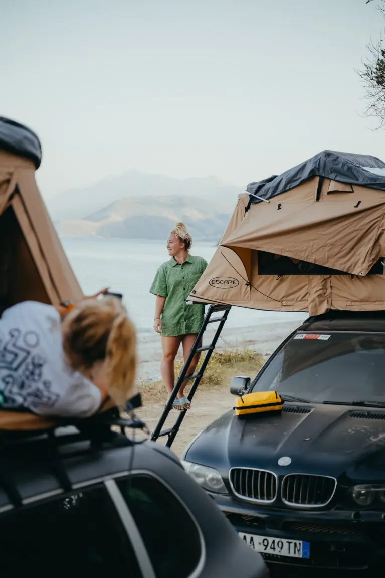 woman standing by rooftop tent car camping in Albania