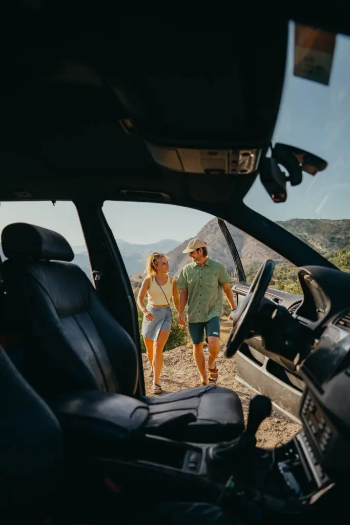 couple holding hands walking from car in albanian mountains